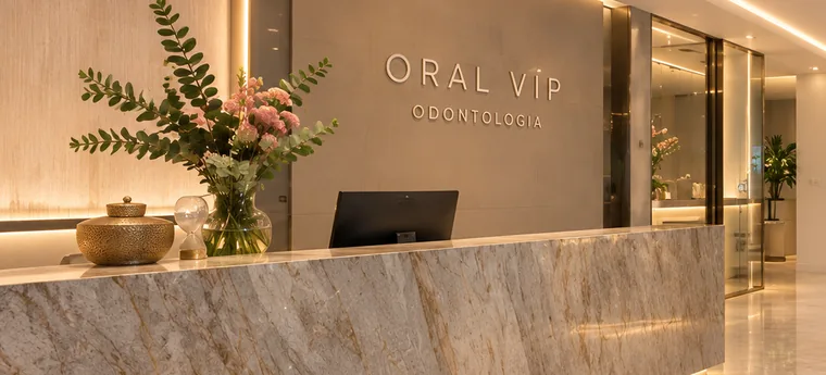Recepção da Oral VIP Odontologia com balcão de mármore e iluminação quente